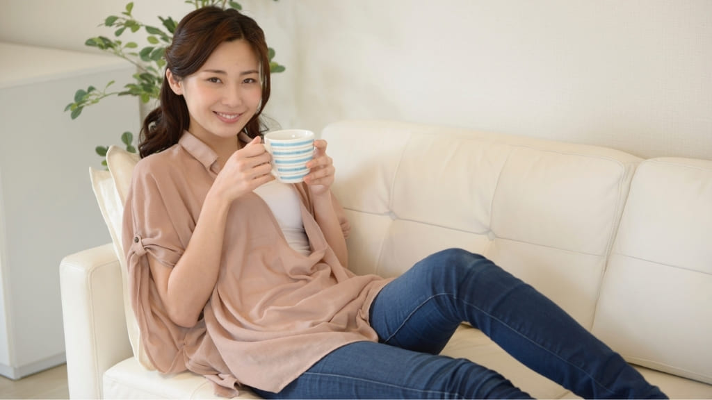 ソファでお茶を飲む女性