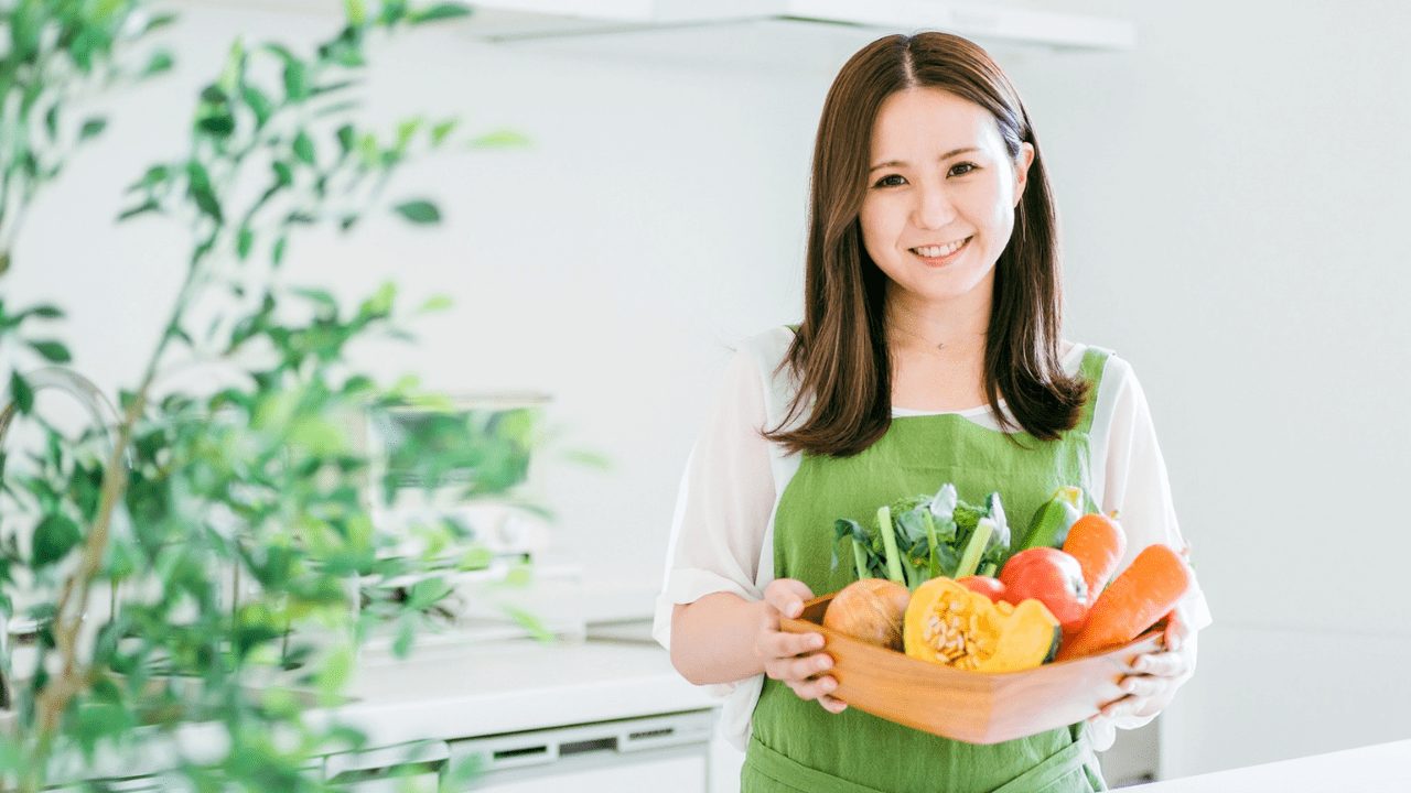 キッチンで野菜を持つ女性